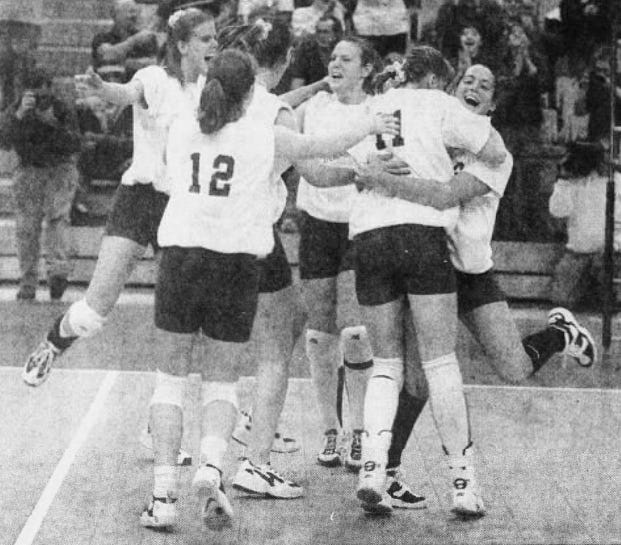 Corning West players celebrate after beating Livonia to win the Class B state volleyball championship in 1997.
