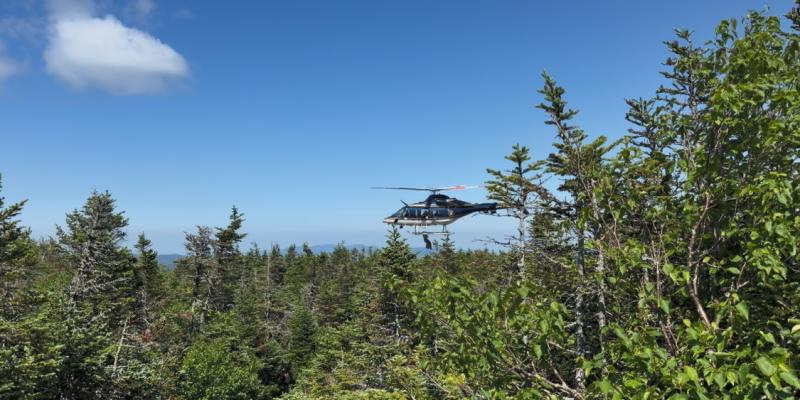 A New York State Police helicopter hovers over Mount Marcy as Forest Ranger Rooney is lowered to an injured hiker with a broken arm during a rescue July 7. After treating the hiker, rescuers hoisted the 61-year-old into the helicopter for transport to a hospital.