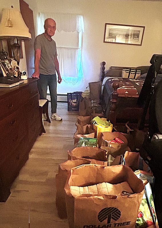 Bill Maloney shows off bags of common household items stored in a bedroom in his West Elmira home. Maloney and other family members purchased more than 2,400 necessities such as toothbrushes, razors and clothing for donation to the Samaritan Center in Elmira.