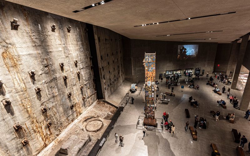 Visitors to the National September 11 Memorial & Museum walk through Foundation Hall, the largest room in the museum May 6, 2026. The hall features a section of the slurry wall which was part of the foundation of the Twin Towers. The hall also includes a steel column known as The Last Column. The column was the final piece of steel removed from Ground Zero in May 2002.