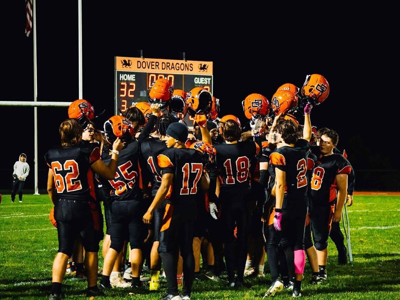 The Dover Dragons football program breaks a huddle after a game
