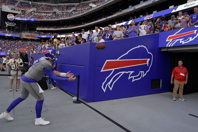 Bills Josh Allen leans forward to catch a throw from a young fan before Return of the Blue and Red practice at Highmark Stadium in Orchard Park on Aug. 8, 2026.  He had been going around the stadium playing catch with kids.