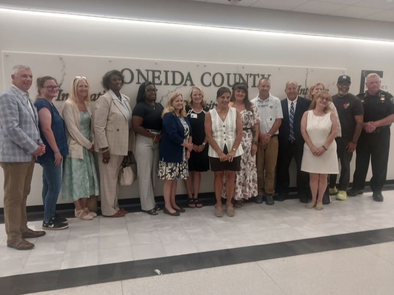 Oneida County Executive Anthony Picente, Community Foundation of Herkimer & Oneida Counties CEO Alicia Dicks, who partner on Oneida County Youth Investment Initiative, pose with other community leaders, grant recipients at Oneida County Office Building on Aug. 10, 2026.