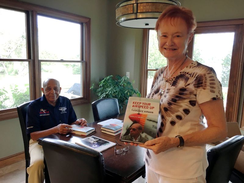 Marsha Bordner holds up a copy of Keep Your Airspeed Up, a book she co-authored with her husband, the late Harold Brown.