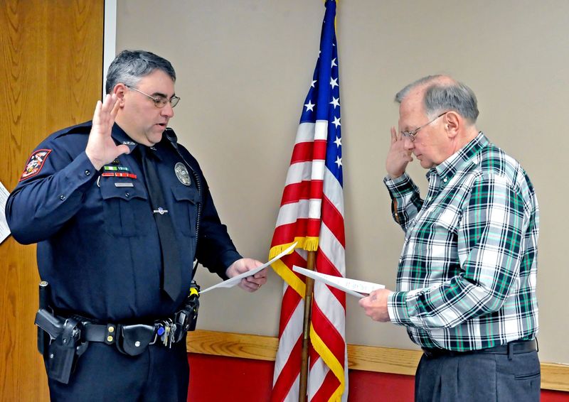 Scott Ries of the Rittman Police Department is sworn in by Mayor William Robertson as a new full-time officer. Ries will also serve as the city's property maintenance inspector, which he has performed since the former inspector resigned in October.