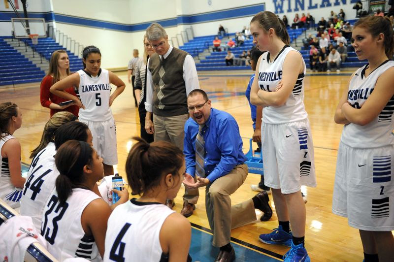 Head Coach Jeff Moore talks strategy with the Lady Devils during a time out Saturday during a game against New Philadelphia at Zanesville High School. New Philadelphia defeated Zanesville, 50-36.