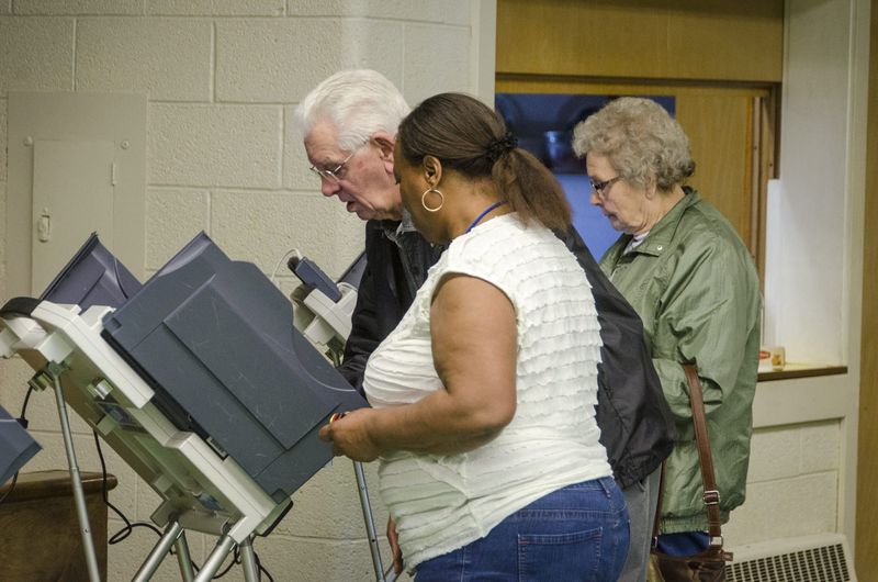 Poll worker Bernice Holder assists Edward and Irene Cervinski at the Mansfield 5A precinct during the 2015 election.