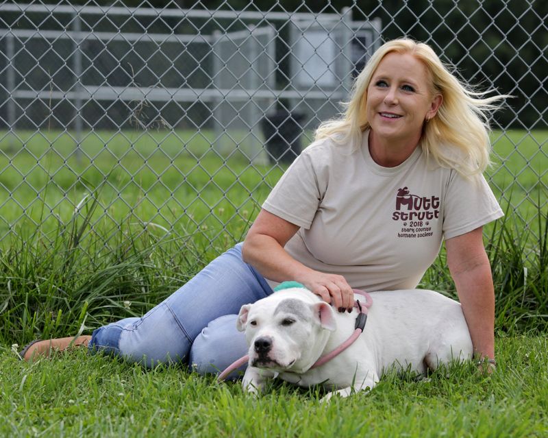 Jackie Godbey, executive director for the Stark County Humane Society, sits with a new dog as it acclimates to the facility in this 2021 file photo.