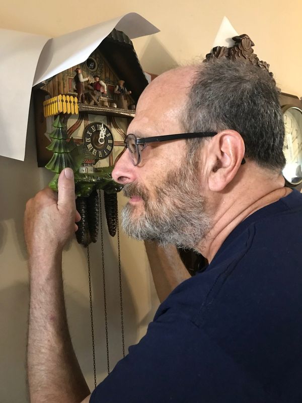 Lancaster Eagle-Gazette columnist Mark Kinsler repairs clocks like this coo-coo clock he is examining.