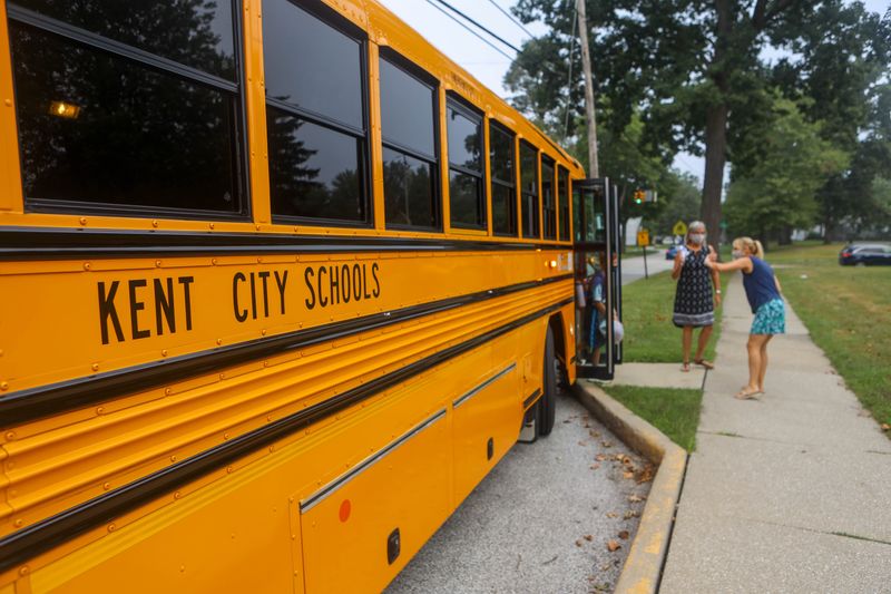 Holden Elementary School administrators and staff great students as the school bus pulls up on the first day of school.