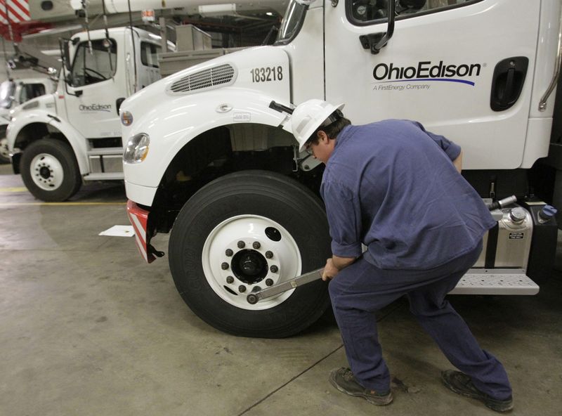 A mechanic for Ohio Edison checks the lug nuts on the FirstEnergy utility's trucks at the Akron Fairlawn campus maintenance building. Karen Schiely/Akron Beacon Journal/Ohio.com file]