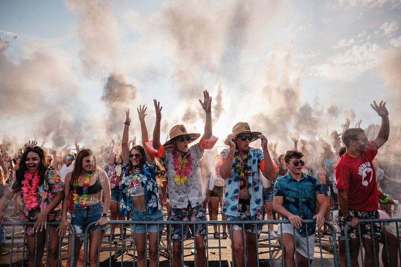 The Dover High School student section celebrates the football team taking the field Thursday, August 19 at Crater Stadium. Pictured at center are, Carter Begue, 18, and Gavyn Gerber, 17.
