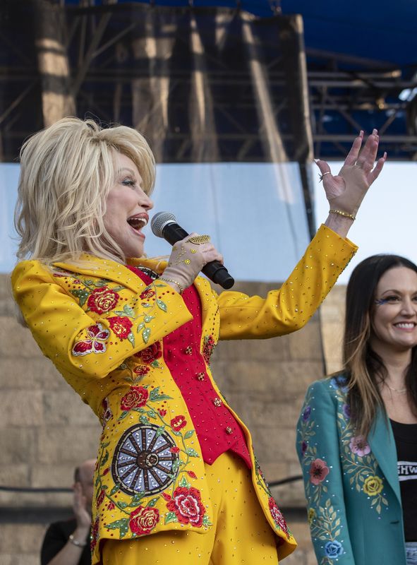 Dolly Parton performs during a headliner set curated by Brandi Carlile(at right)during the 60th anniversary of the Newport Folk Festival Saturday at Fort Adams State Park