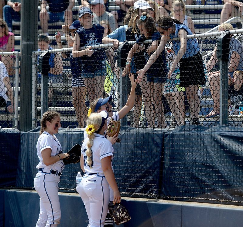 Louisville softball players interact with some young fans in 2019 after a regional final win on the way to winning a Division I state championship. Players on the current Louisville state finalist team were among the youngsters who cheered that team on.
