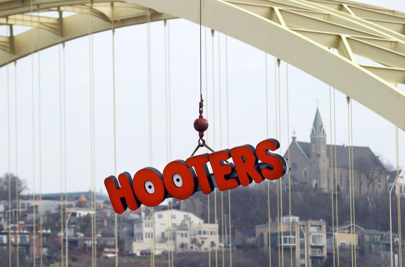 Against a backdrop of Mount Adams and the Big Mac Bridge, a crane lifts the Hooters sign from the restaurant on Newport's riverfront in 2015, as the letters were being replaced.