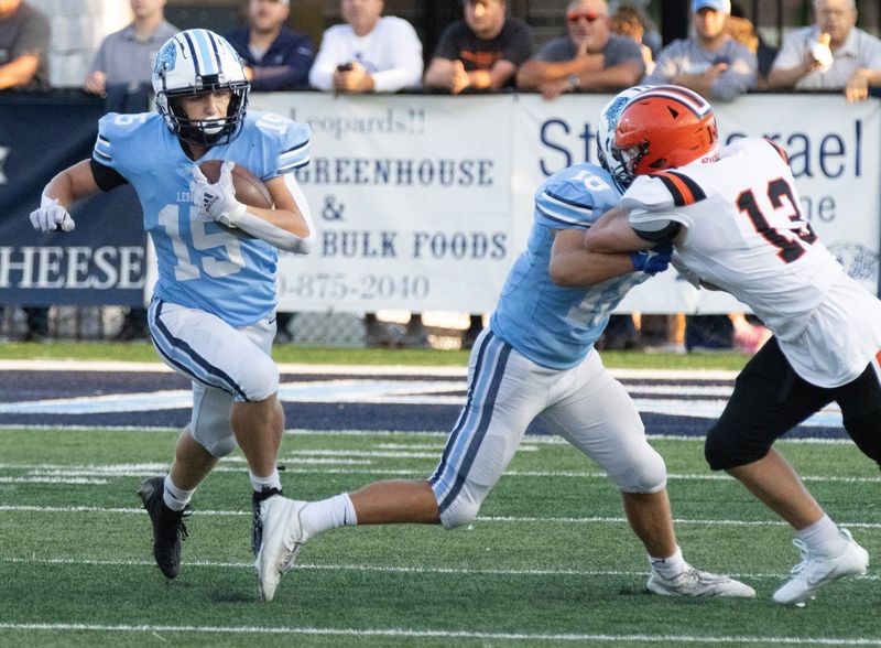 Louisville’s Owen DiMarzio runs behind the blocking of Gabe Stoffer on Hoover’s Sam Hassen during the first quarter Friday, Sept. 8, 2023.