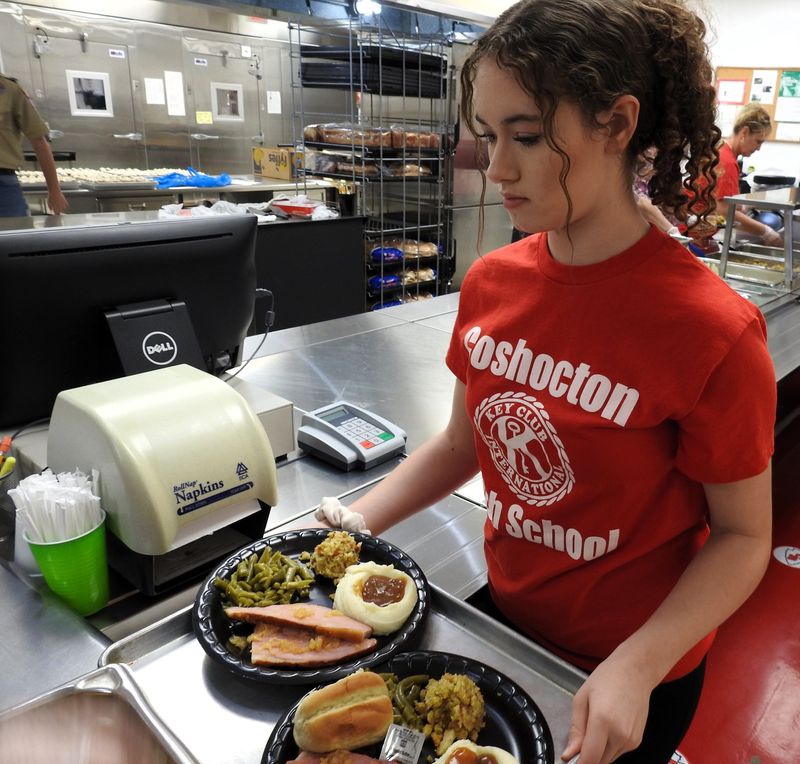 Zaelyn Carroll gets meals to serve people attending Coshocton High School's annual Thanksgiving dinner in this Tribune file photo from 2023. Every year, about 100 students assist with the community meal that feeds close to 400 people on average.