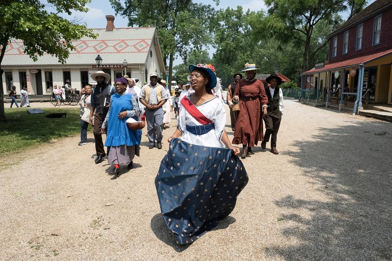 Valerie Boyer, dressed as Lady Liberty, leads the procession during the Juneteenth Jubilee Day Festival in the Ohio Village on the grounds of the Ohio History Center on June 18, 2023.