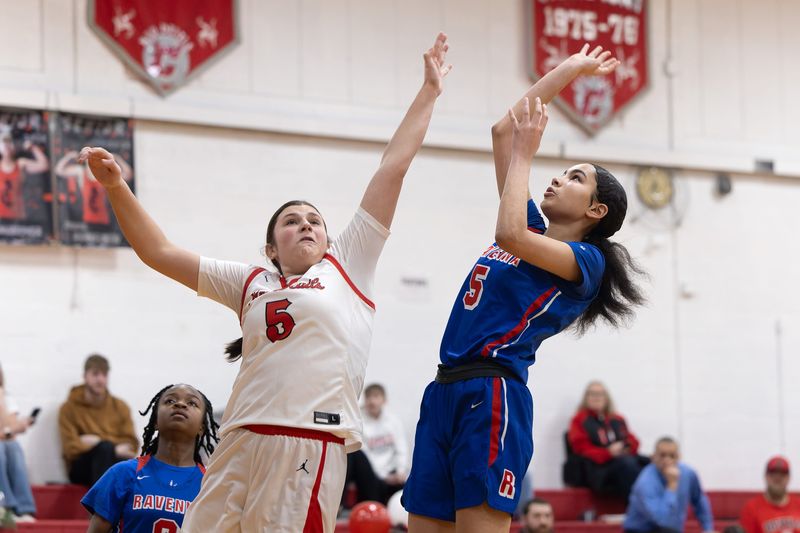 Ravenna sophomore Jalysia Thompson goes up to score as Crestwood junior forward Madison Dustman leaps up to block during Saturday morning's basketball game in Mantua, OH.