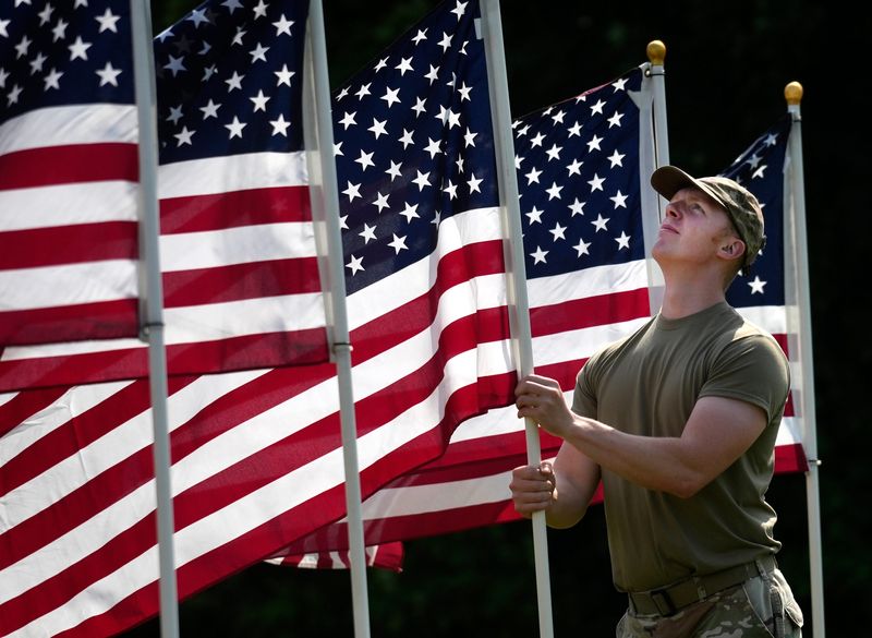 Tech Sgt. Kody Moran, of the Ohio Air National Guard, 123rd Air Control Squadron out of Blue Ash, Ohio, helps with the flag display at The Arlington Memorial Gardens in Springfield Township, Wednesday, May 22, 2024. The 1,000 flags are part of the 9th annual Field of Memories to honor, remember and celebrate men and women who paid the ultimate price in defending the nation. The public is invited to partake in activities, beginning Friday and running through Monday. The money raised goes to “Operation Ramp It Up," a local non-profit that builds mobility ramps for veterans.