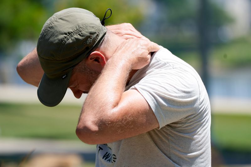 Joel Armor, 46, applies sunscreen to the back of his neck, Sunday, June 16, 2024, at Small Riverfront Park in Cincinnati. The first heat wave of the year has hit with high temperatures continuing into next week.