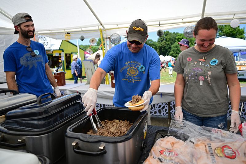 Len Barcikoski, center, Robert Fathauer, left, and Nikki Fathauer work on preparing ox sandwiches during the 2024 Ox Roast Fair at St. Joseph Parish in Mantua.