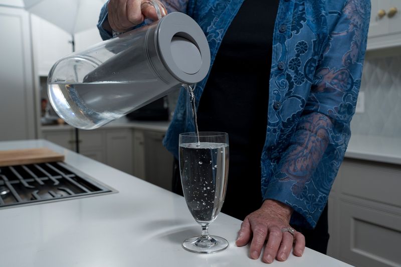 Sharon Scovanner pours drinking water from a filtration pitcher she uses at her home in Loveland.