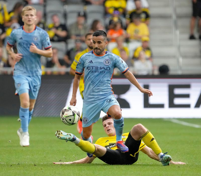 Crew midfielder Sean Zawadzki slides in to kick the ball away from New York City midfielder Maximiliano Moralez during a game last August.