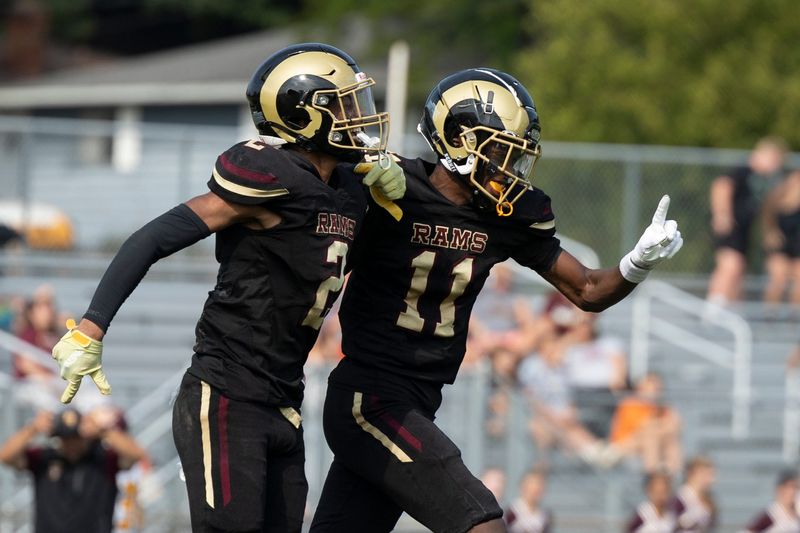 Akron Garfield’s Ziiyahn Blair and Barry Brima celebrate after a goal line defensive stop to clinch the win over visiting Southeast, Aug. 24, 2024.