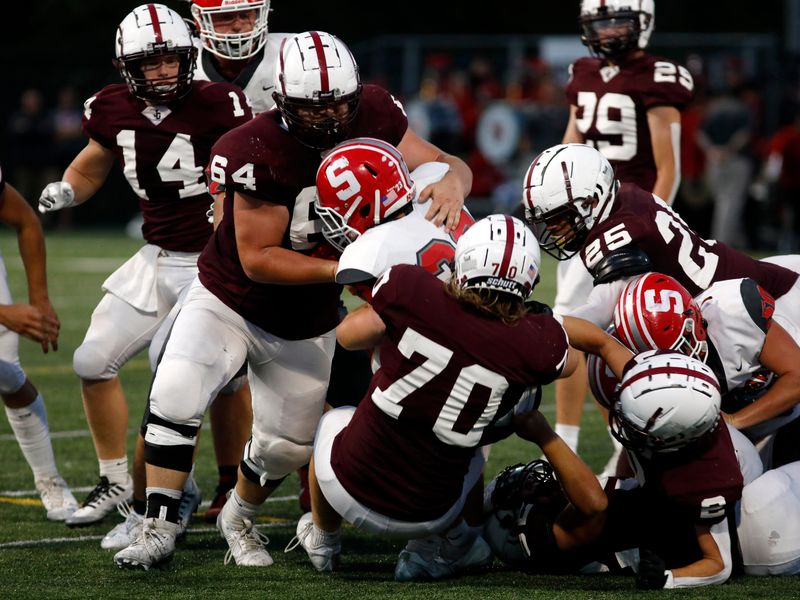 John Glenn's Tanner Whiteman, left, and Kian Barton make a tackle during a 23-17 overtime loss to visiting Sheridan on Friday, Sept. 20, 2024, in New Concord.