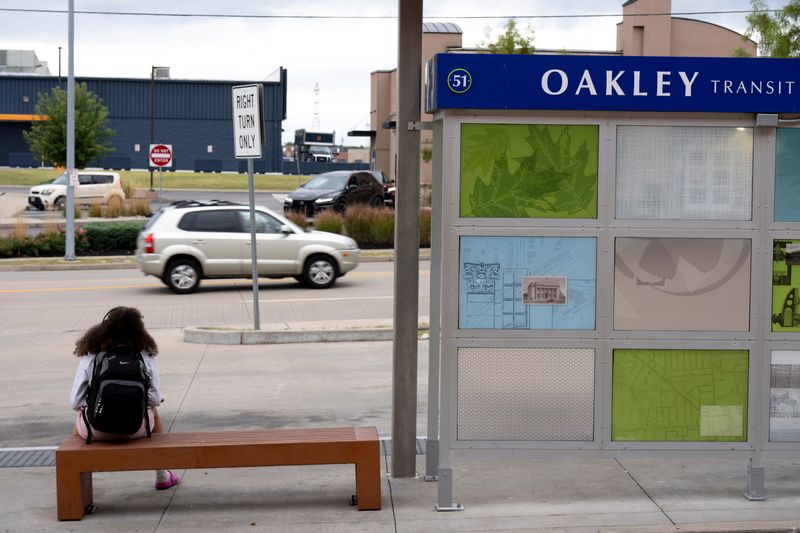 A student waits at the Oakley Transit Station.
