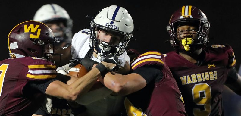 Hoban running back Brayton Feister, center, picks up a first down against a host of Walsh defenders Oct. 4, 2024, in Cuyahoga Falls.