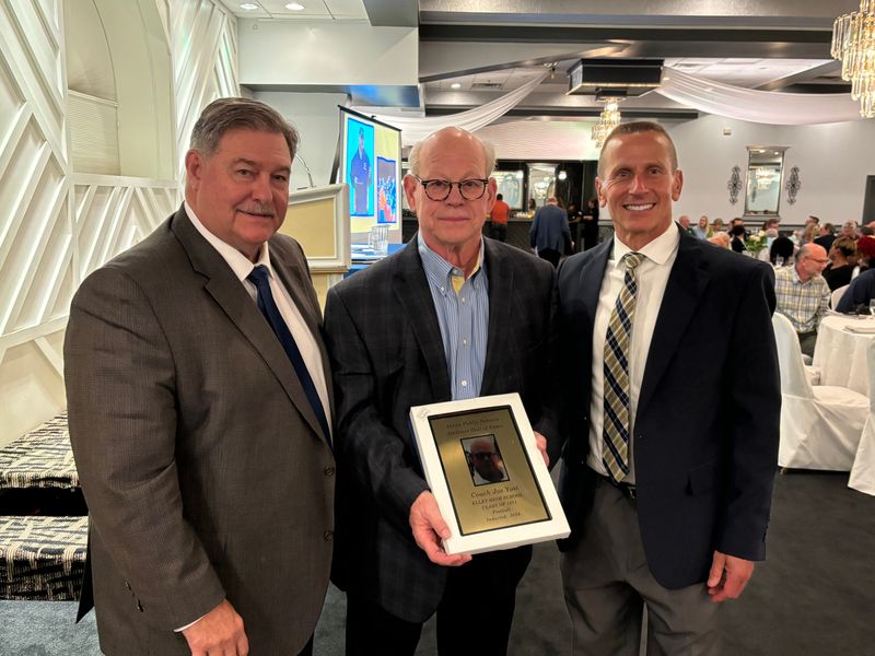 Former longtime Ellet High School football coach Joe Yost, center, poses for a photograph with Akron Public Schools administrators Ron Linger, left, and Joe Vassalotti, right, after Yost was inducted into the APS Athletics Hall of Fame on Oct. 5, 2024, in Akron, Ohio.