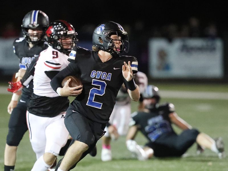 CVCA quarterback Charley Levak runs for yardage as Manchester linebacker Zeke Sundbury closes in Oct. 25, 2024, in Cuyahoga Falls.