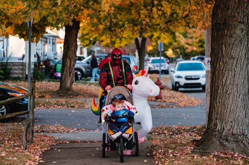 Trick-or-treaters walk along a street in New Philadelphia in 2024. This  year the city will trick-or-treating from 6 to 8 p.m. Oct. 25.