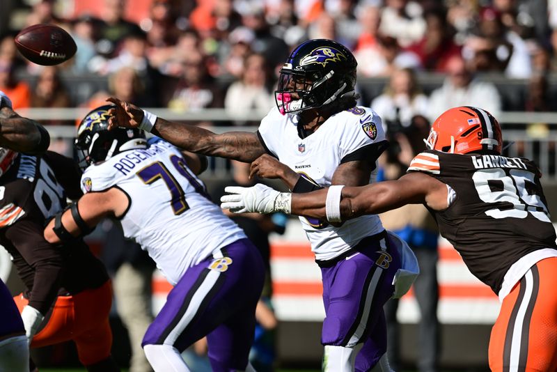 Baltimore Ravens quarterback Lamar Jackson (8) throws a pass as Cleveland Browns defensive end Myles Garrett (95) rushes on Oct. 27, 2024, in Cleveland, Ohio.