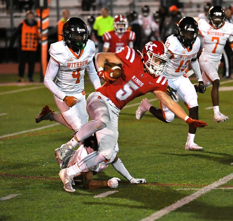 Carson Lindholm (5) is tripped up by the Withrow defense after a short gain for Kings in Division II first round OHSAA football playoffs, Nov. 1, 2024.