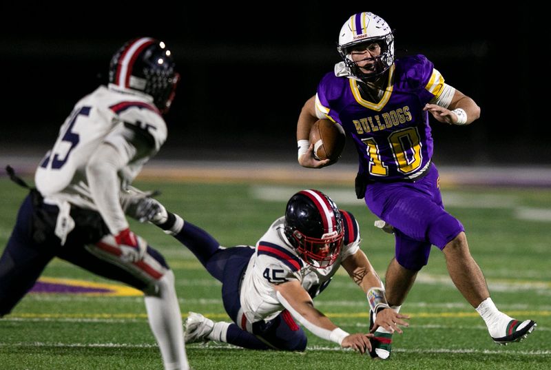 Bloom-Carroll quarterback Ethan Thanthanavong (10) avoids the tackle from the Bishop Hartley defenders in varsity football action at Bloom-Carroll High School on November 1, 2024, in Carroll, Ohio. Bloom-Carroll defeated Bishop Hartley 44-43.