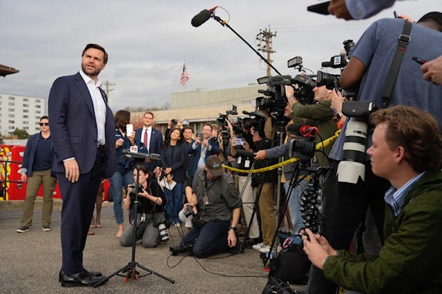 Republican vice presidential nominee JD Vance looks back at his family while speaking to media in East Walnut Hills on Election Day. A resident of the neighborhood, Vance voted at St. Anthony of Padua Catholic Church.