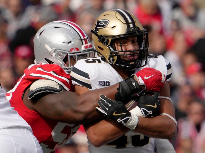 Nov 9, 2024; Columbus, Ohio, USA; 
Purdue Boilermakers running back Devin Mockobee (45) is tackled by Ohio State Buckeyes defensive tackle Ty Hamilton (58) during the first half of Saturday’s football game at Ohio Stadium.