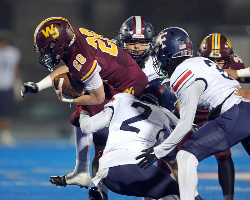Walsh Jesuit running back Marty Tobin rushes against Austintown Fitch defensive back Junie Higgs during the first half of a Division II regional semifinal football game at Ravenna High School, Friday, Nov. 15, 2024, in Ravenna, Ohio.