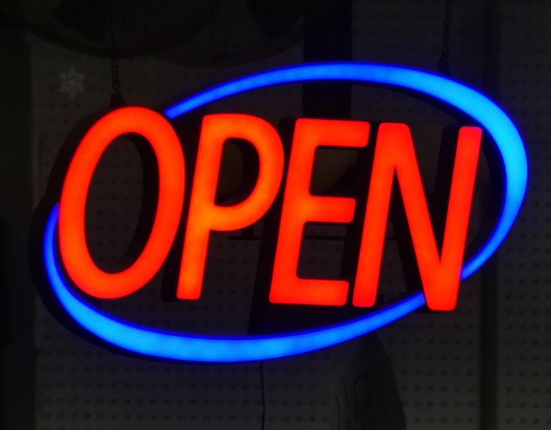 A sign shows a business is open.