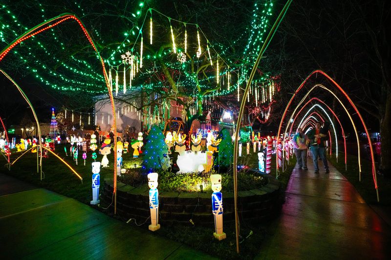 People walk on the sidewalk under the Christmas light on Tuesday, Dec. 10, 2024 in Westerville, Ohio.