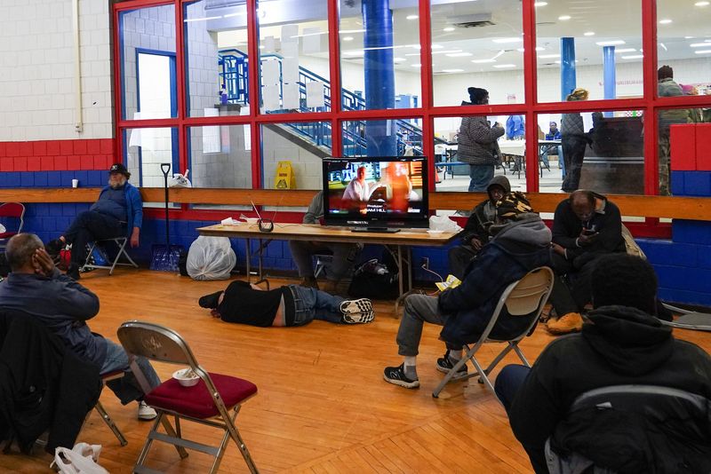 People gather and watch television, Tuesday, Jan. 7, 2025, at the Over-the-Rhine Recreation Center in Over-the-Rhine. The Over-the-Rhine Recreation Center will be open as a daytime cold weather shelter that provides food and shelter up to Friday, Jan. 10.