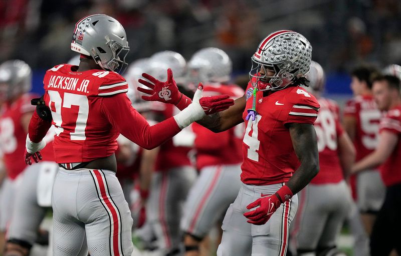 Ohio State Buckeyes defensive end Kenyatta Jackson Jr. (97) and Ohio State Buckeyes wide receiver Jeremiah Smith (4) do a hand shake during final warm ups at the Cotton Bowl Classic before their game against Texas Longhorns in the College Football Playoff semifinal game at AT&T Stadium in Arlington, Texas on January, 10, 2025.