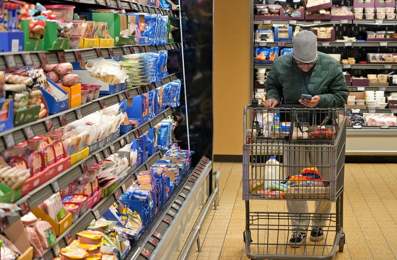 Jontayesha Brown checks the Aldi app, which she uses as a shopping list, at the grocery chain's location on Romig Road in Akron, Ohio, on Friday Jan. 10, 2025.