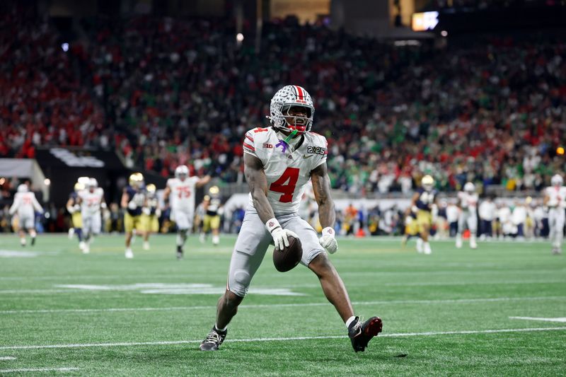 Jan 20, 2025; Atlanta, GA, USA; Ohio State Buckeyes wide receiver Jeremiah Smith (4) reacts after making a catch against the Notre Dame Fighting Irish during the second half the CFP National Championship college football game at Mercedes-Benz Stadium. Mandatory Credit: Mark J. Rebilas-Imagn Images