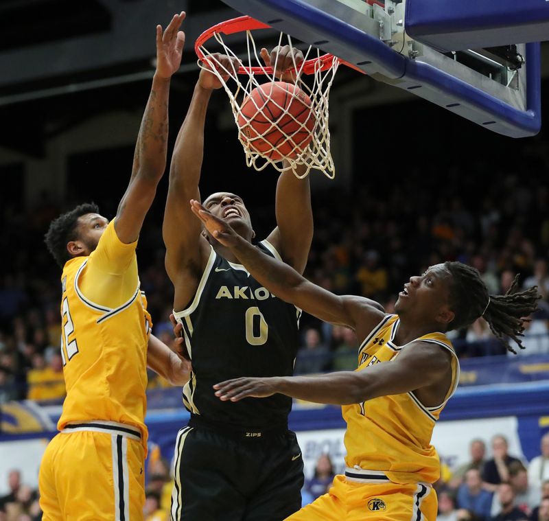 Akron forward Amani Lyles dunks between Kent State center Cli'Ron Hornbeak (42) and guard Jamal Sumlin (4) during the first half, Friday, Jan. 31, 2025, in Kent.