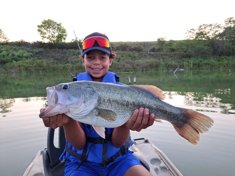 Aven Porrini shows off the large mouth bass he caught during a 2025 fishing trip with Sol Curtis in Muskingum County. The Ohio Department of Natural Resources says southeastern Ohio lakes and reservoirs are excellent places to fish for bass, saugeye, catfish and crappie.