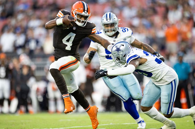 Sep 8, 2024; Cleveland, Ohio, USA; Cleveland Browns quarterback Deshaun Watson (4) pushes Dallas Cowboys safety Juanyeh Thomas (30) away as he runs the ball during the fourth quarter at Huntington Bank Field. Mandatory Credit: Scott Galvin-Imagn Images